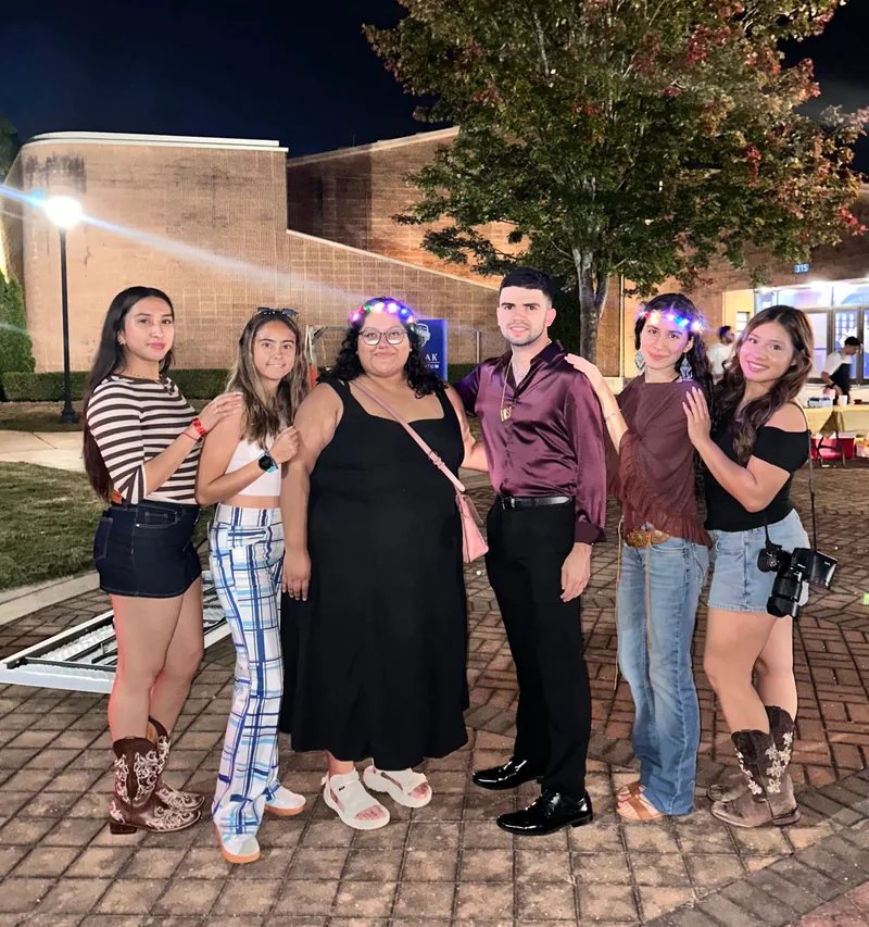Six members of LASO's leadership team at Noche de Disco, wearing light-up flower crowns and '70s-style outfits